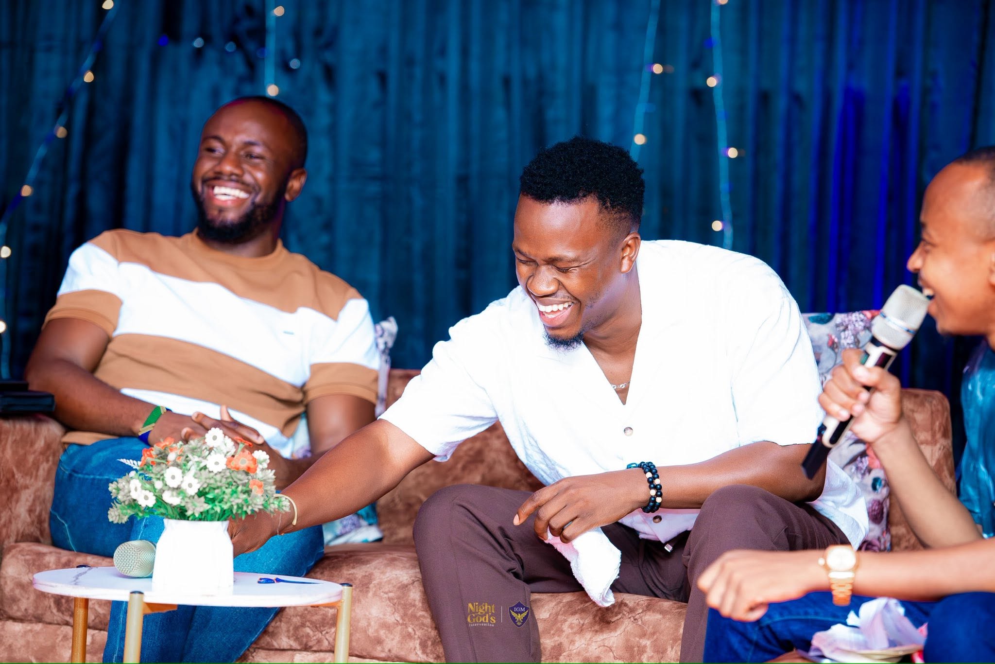 Mika Chavala laughing on stage at a church event in Kampala
